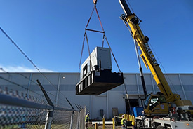 Rehlko generator held with a large crane at job site